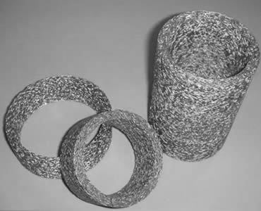 Three cylindrical knitted wire mesh filters.